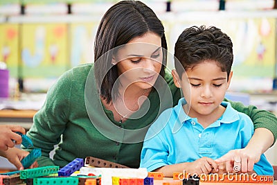 Elementary Pupil Counting With Teacher In Classroom