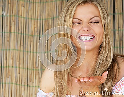 Embarrassed young woman blowing kiss and smiling