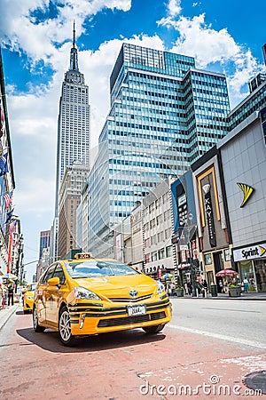 Empire State building and yellow taxi cab on the street
