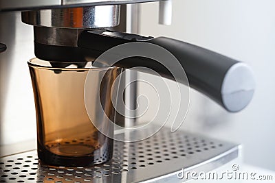Empty glass cup in espresso coffee machine