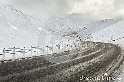 Empty mountain road on a cloudy winter day.