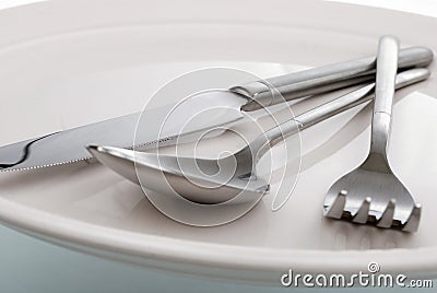 Empty plate, fork, spoon and table-knife