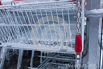 Empty shopping cart with coin lock and snow on it
