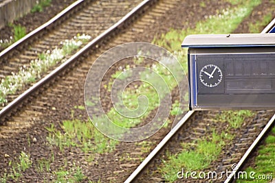 Empty time table with clock at rail tracks