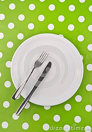 Empty white flat plate with fork and knife