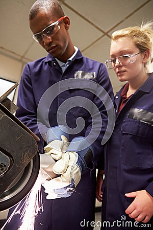 Engineer Teaching Apprentice To Use Grinding Machine