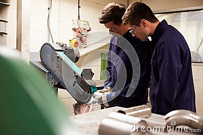 Engineer Teaching Apprentice To Use Grinding Machine