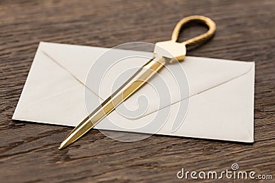 Envelope and brass letter opener on a desk