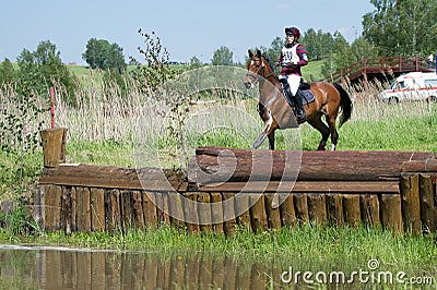 Equestrian sport. Cross-coutry. Woman on horse is Drop fence in Water jump