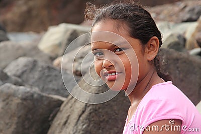 Ethnic school girl on beach with smiling eyes