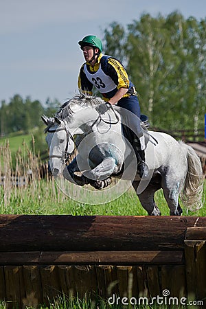 Eventer on horse is Drop fence in Water jump