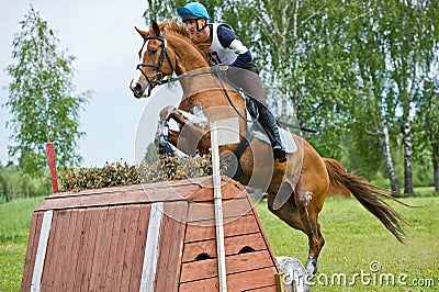 Eventer on horse is jump the cross-country fence