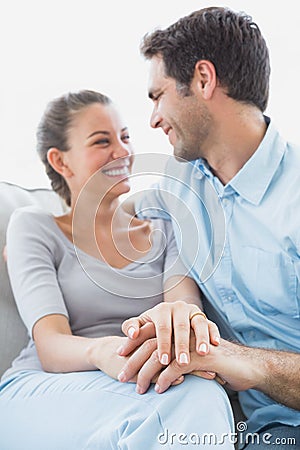 Excited couple looking at each other on the couch