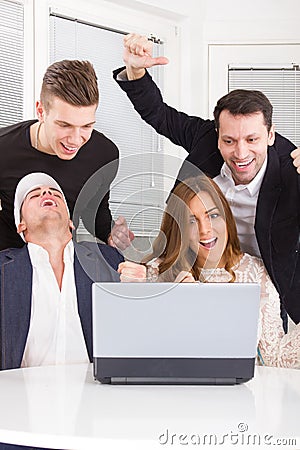 Excited happy group of friends winning online using laptop