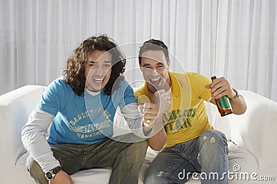 Excited Men Watching Television With Beer Bottle