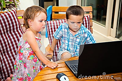 Excited siblings with laptop computer