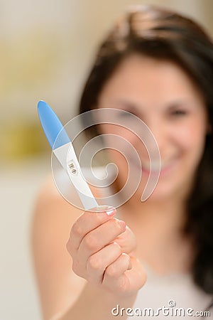 Excited woman with pregnancy test