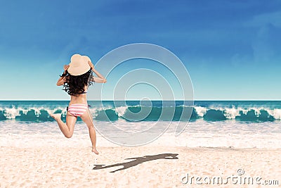 Excited woman running into the sea