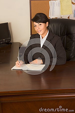 Executive assistant woman in business suit writing