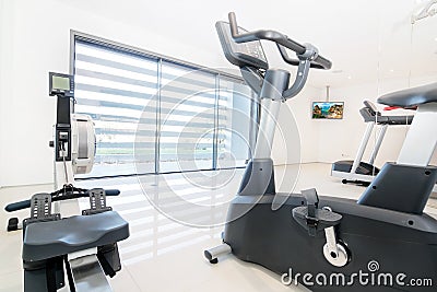 Exercise bike and rowing simulator in a modern luxe gym.