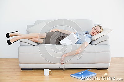 Exhausted young businesswoman sleeping lying on her couch
