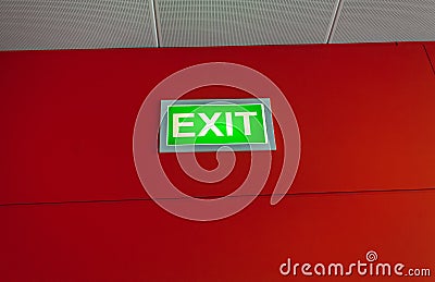 Exit sign glowing on red wall