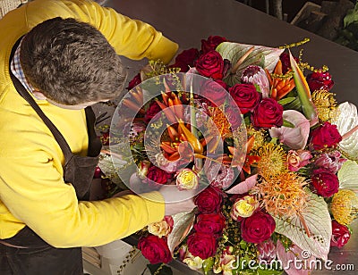 In exotic flower shop florist finishing bouquet