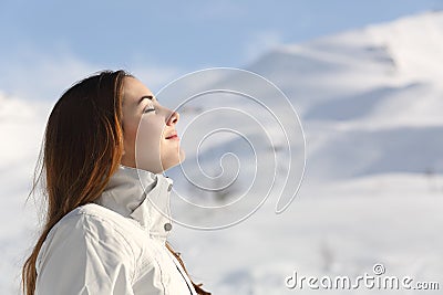 Explorer woman breathing fresh air in winter in a snowy mountain