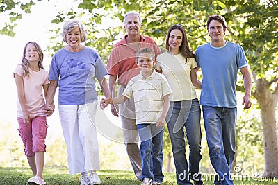 Extended family walking in park holding hands