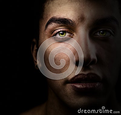 Face of man in the dark with beautiful green eyes