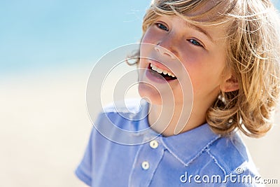 Face shot of laughing boy outdoors.