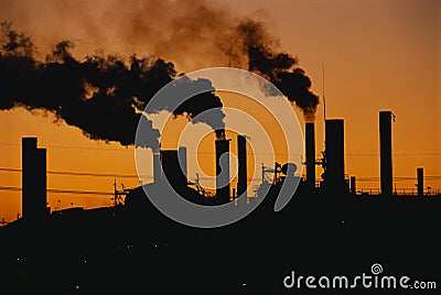 Factory with smokestacks at sunset