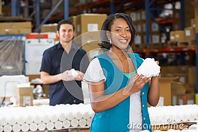 Factory Worker Checking Goods On Production Line