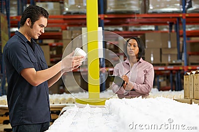 Factory Worker And Manager Checking Goods On Production Line