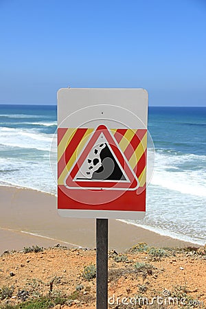 Danger falling rocks sign near a beach