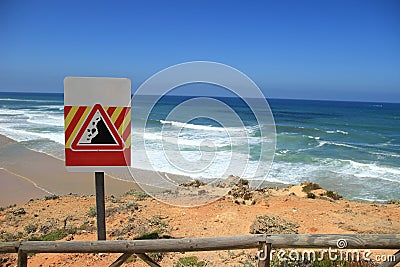 Danger falling rocks sign near a beach