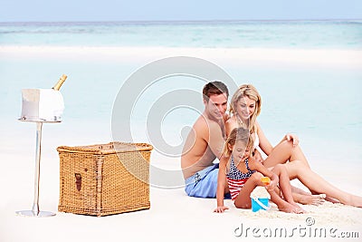 Family On Beach With Luxury Champagne Picnic