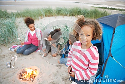 Family Camping On Beach And Toasting Marshmallows