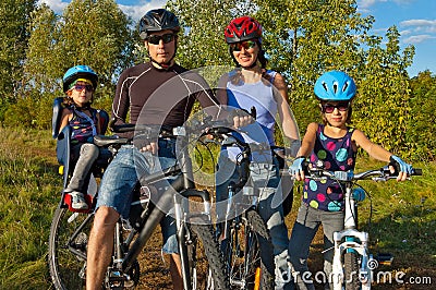 Family cycling outdoors. Parents with kids on bike