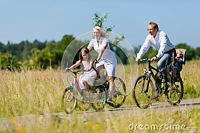 Family cycling outdoors in summer