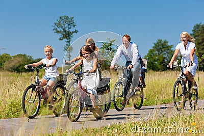 Family cycling outdoors in summer