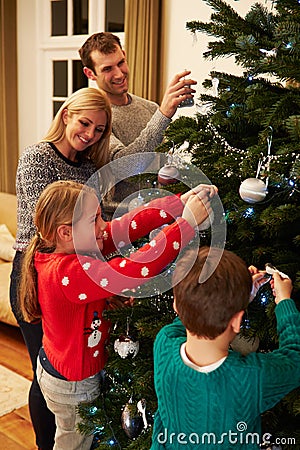 Family Decorating Christmas Tree At Home Together