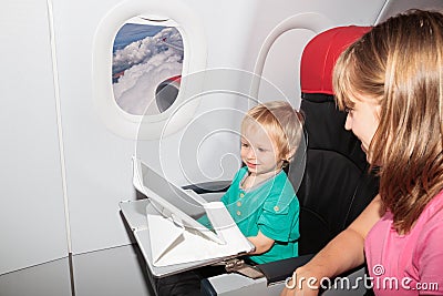 Family with digital tablet in plane