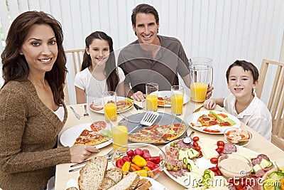 Family Eating Pizza & Salad At Dining Table