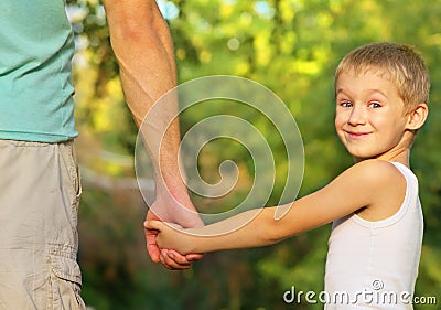 Family Father Man and Son Boy Child holding hand in hand Outdoor
