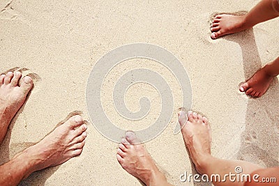 Family footprints in the sand on the seashore