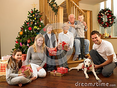 Family with gifts in front of Christmas tree