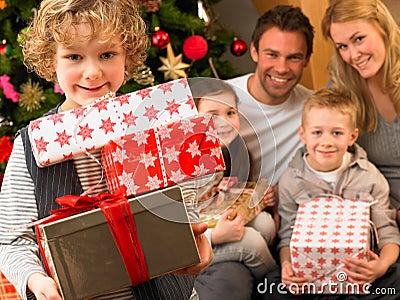 Family with gifts in front of Christmas tree