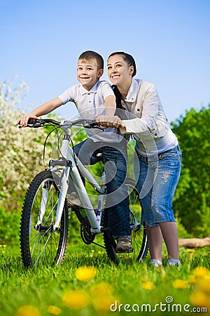 Family in a green park with a bike