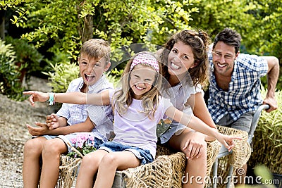 Family having fun with a barrow in a greenhouse